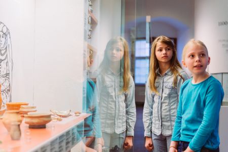 Blick in das Museum, Kinder schauen sich Ausstellungsobjekte an